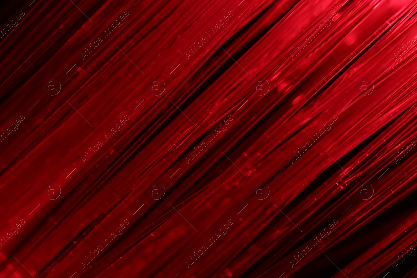 Photo of Optical fiber strands transmitting red light, macro view