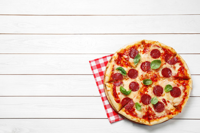 Hot delicious pepperoni pizza on white wooden table, top view. Space for text