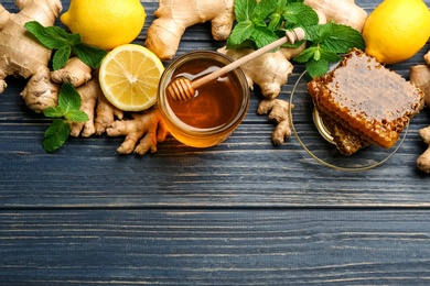 Photo of Ginger and other natural cold remedies on blue wooden table, flat lay. Space for text