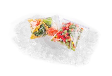 Bags of different frozen vegetables and ice isolated on white