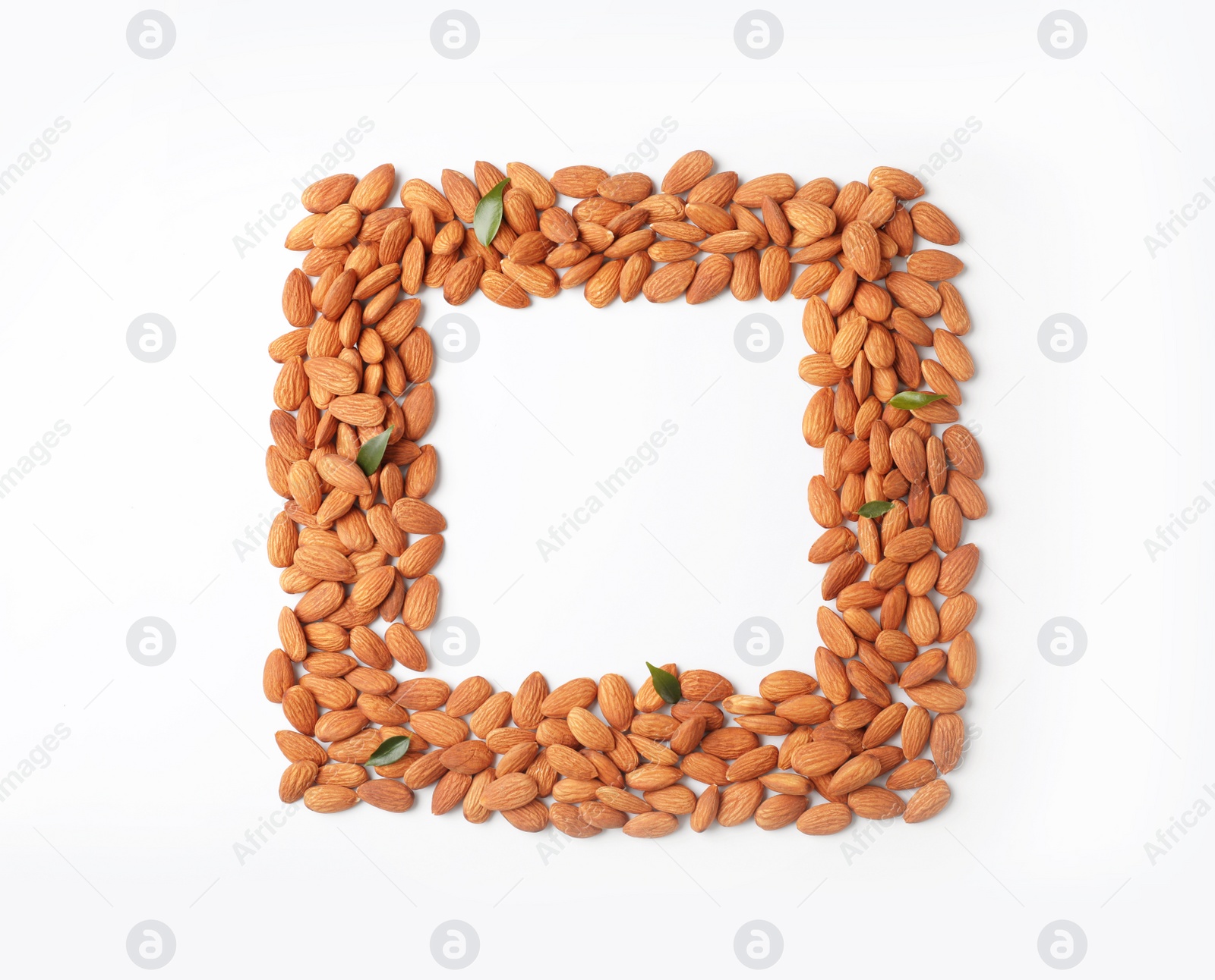 Photo of Frame made of organic almond nuts on white background. Space for text