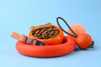 Photo of Dry pet food and toys on light blue background. Shop items