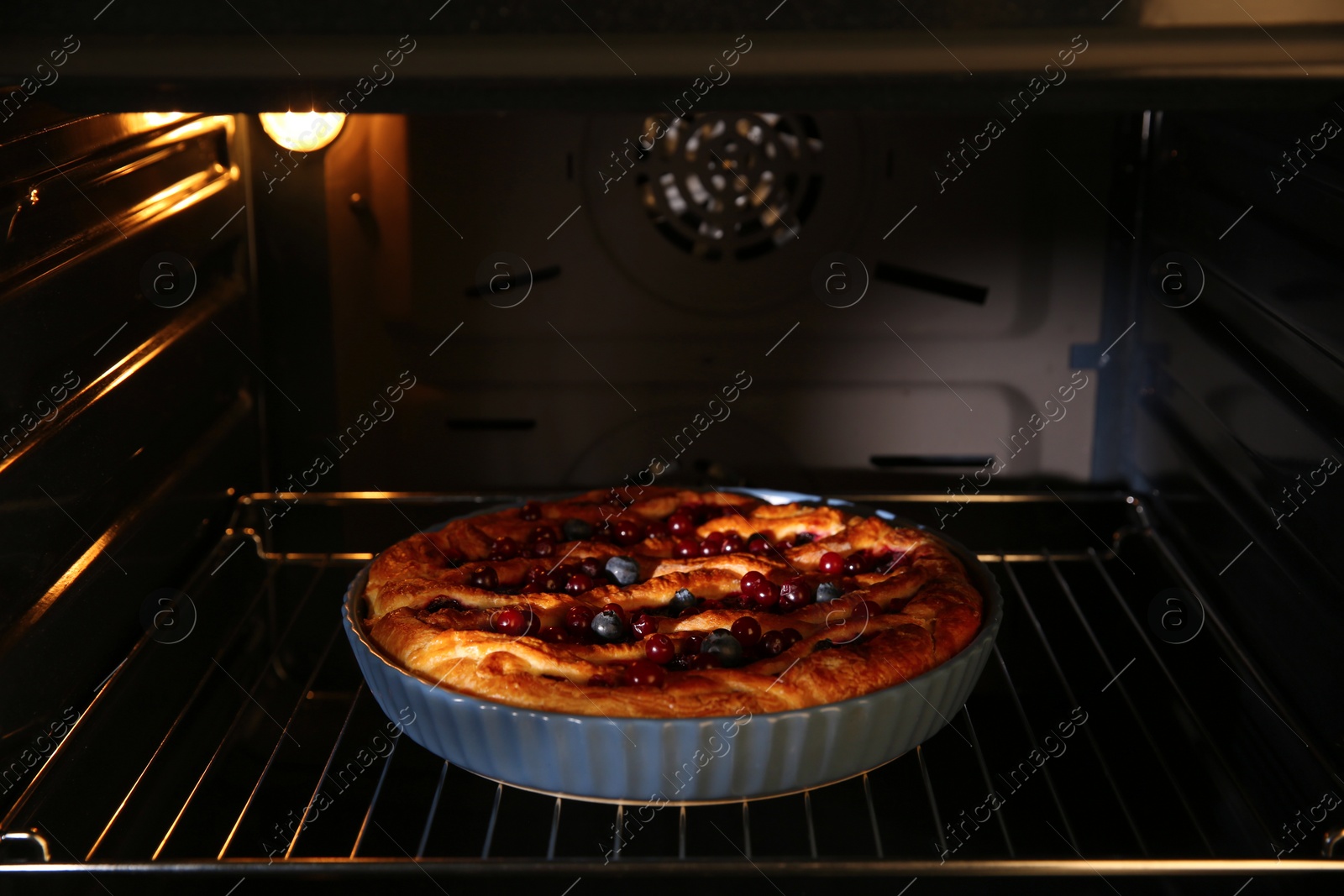 Photo of Delicious homemade currant pie in oven, closeup