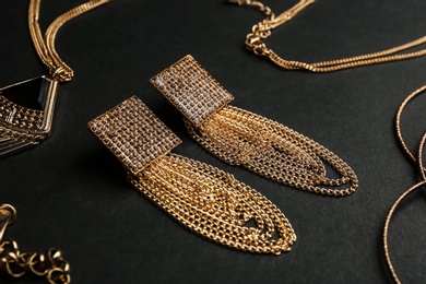 Photo of Set of gold jewelry on black background, closeup