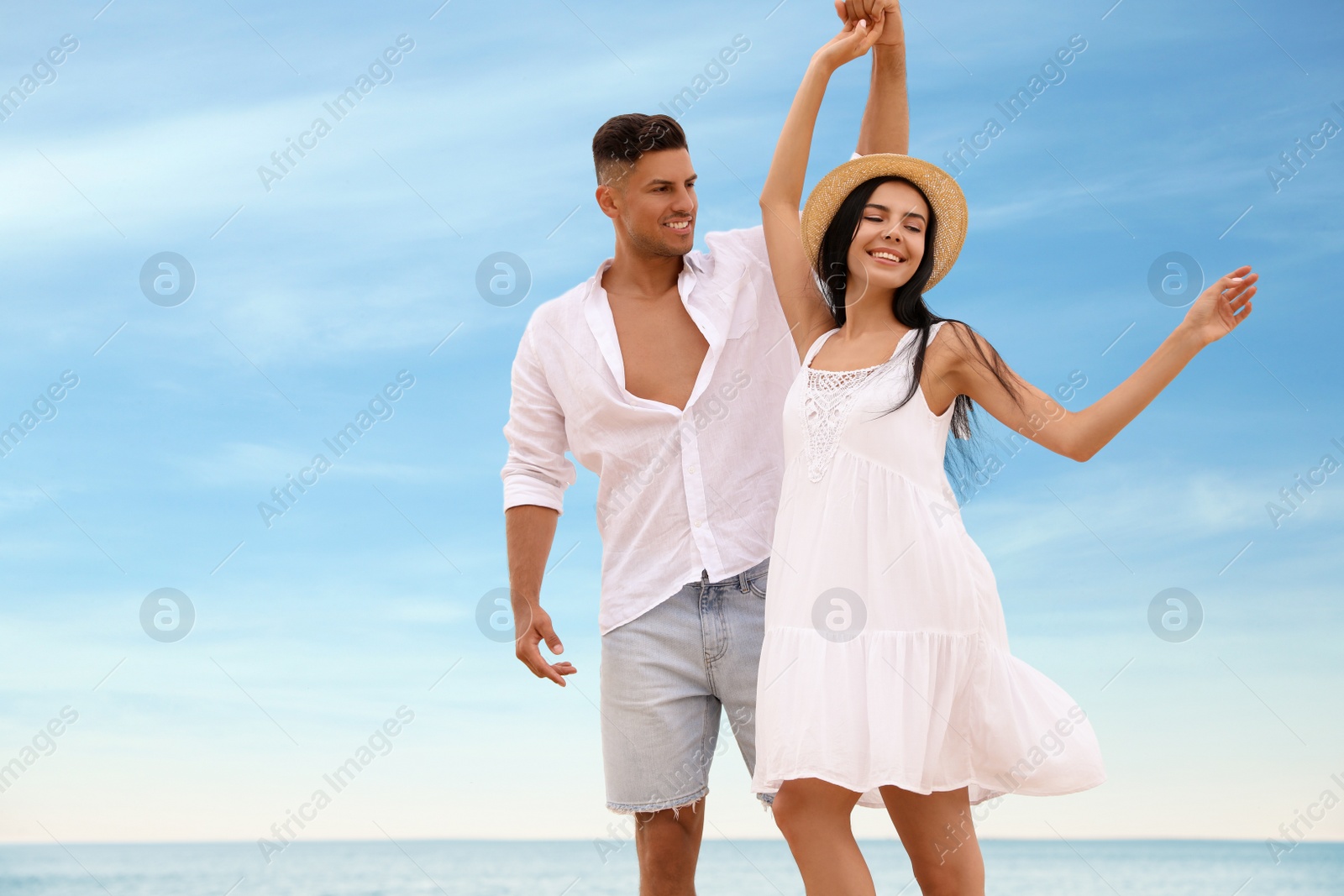 Photo of Lovely couple dancing near sea in summer