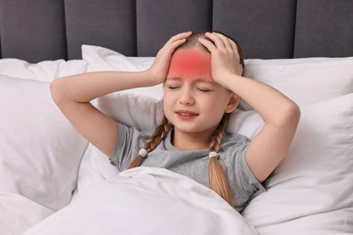 Little girl suffering from headache in bed at home