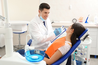 Photo of Professional dentist working with patient in clinic