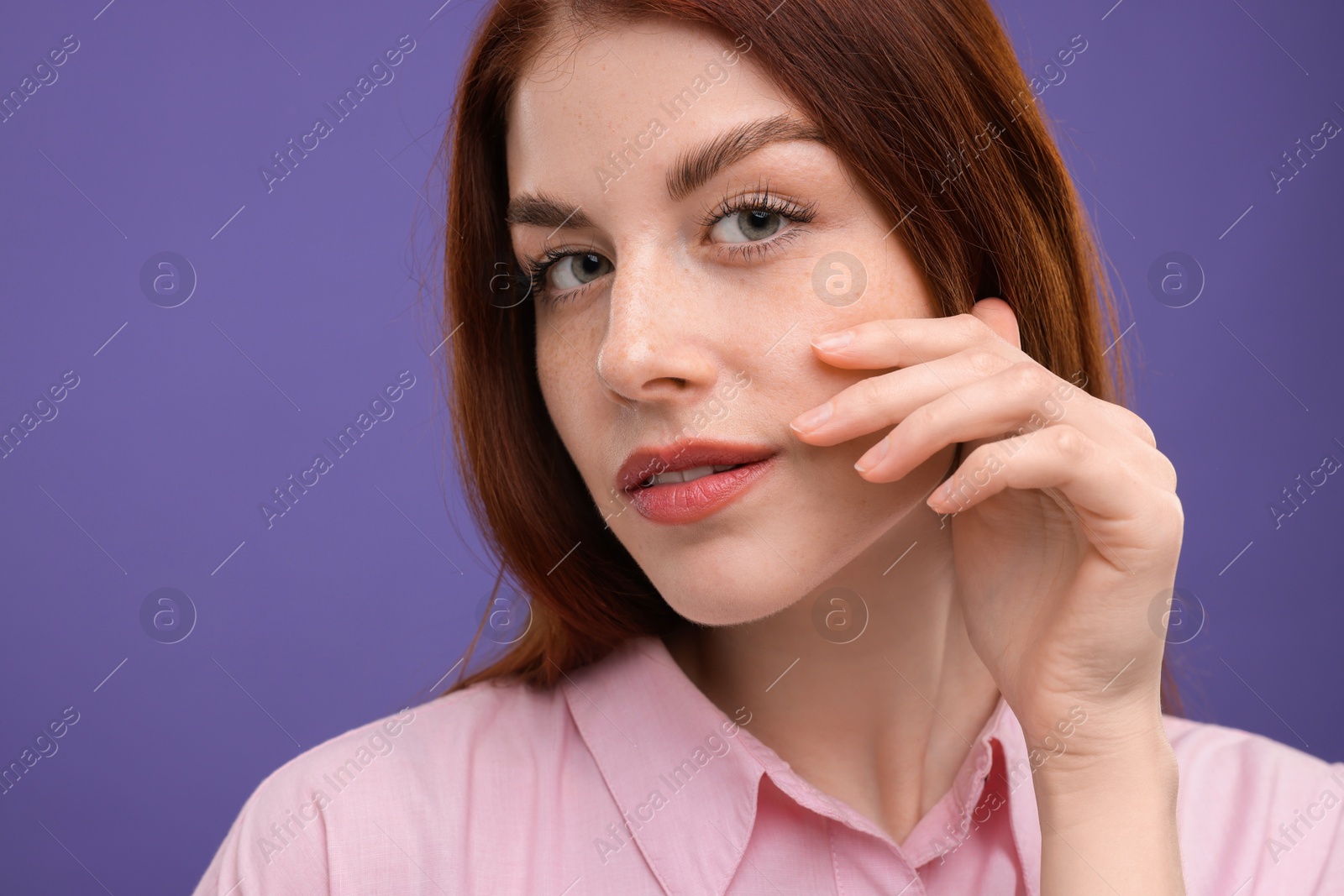 Photo of Portrait of beautiful woman with freckles on purple background, closeup