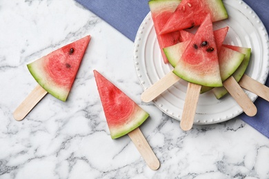 Flat lay composition with watermelon popsicles on marble background