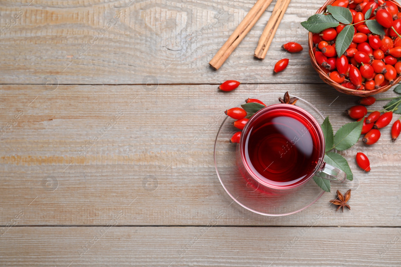 Photo of Flat lay composition with aromatic rose hip tea on wooden table. Space for text