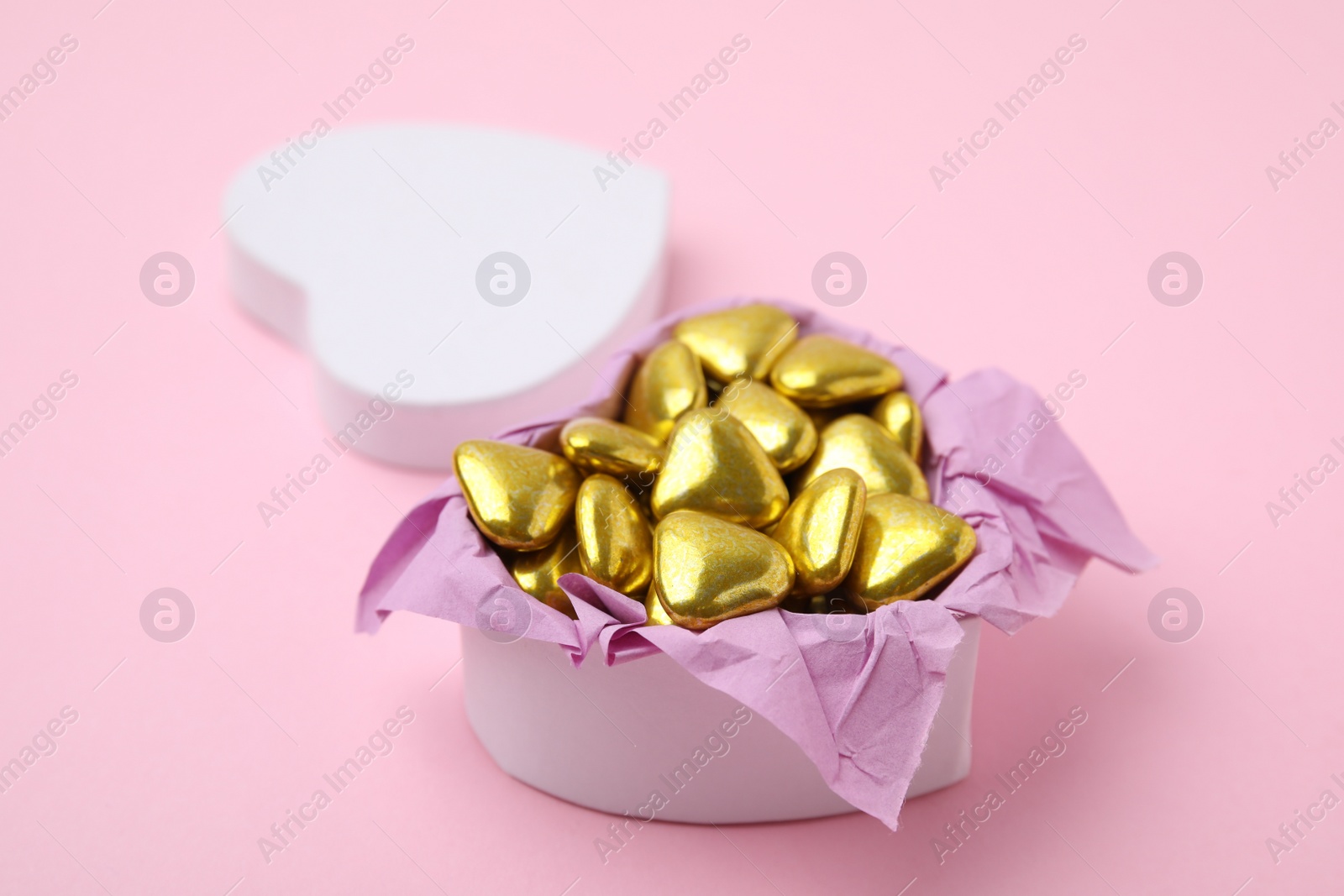 Photo of Box with delicious heart shaped candies on pink background