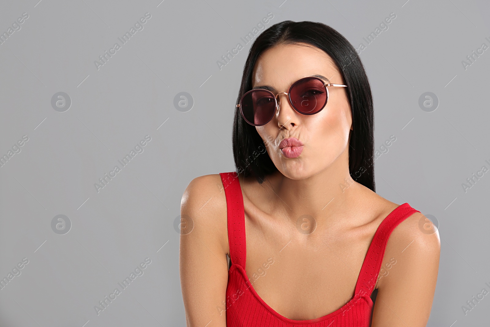 Photo of Beautiful woman wearing sunglasses on grey background