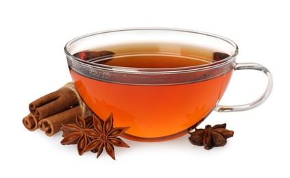 Photo of Glass cup of hot tea with anise stars and cinnamon sticks on white background