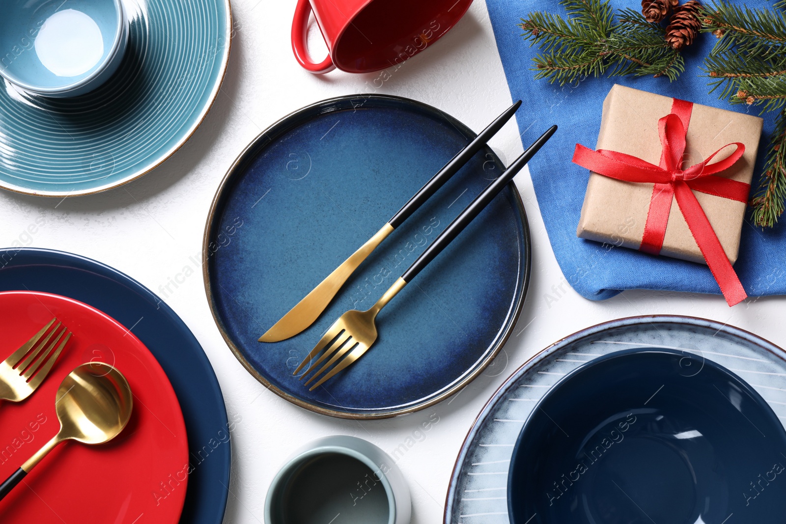 Photo of Flat lay composition with tableware, gift and fir branch on white background