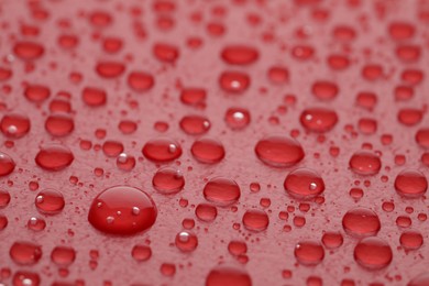 Water drops on red background, closeup view