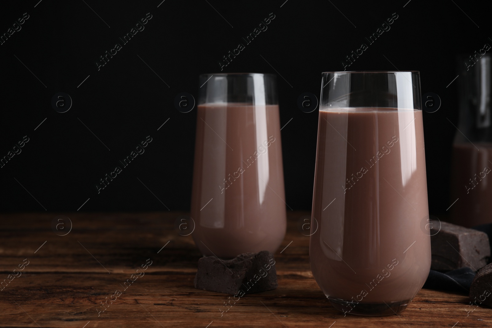 Photo of Delicious chocolate milk in glasses on wooden table