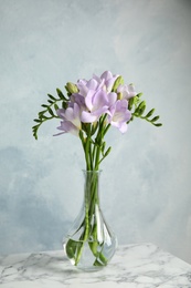 Photo of Bouquet of fresh freesia flowers in vase on table