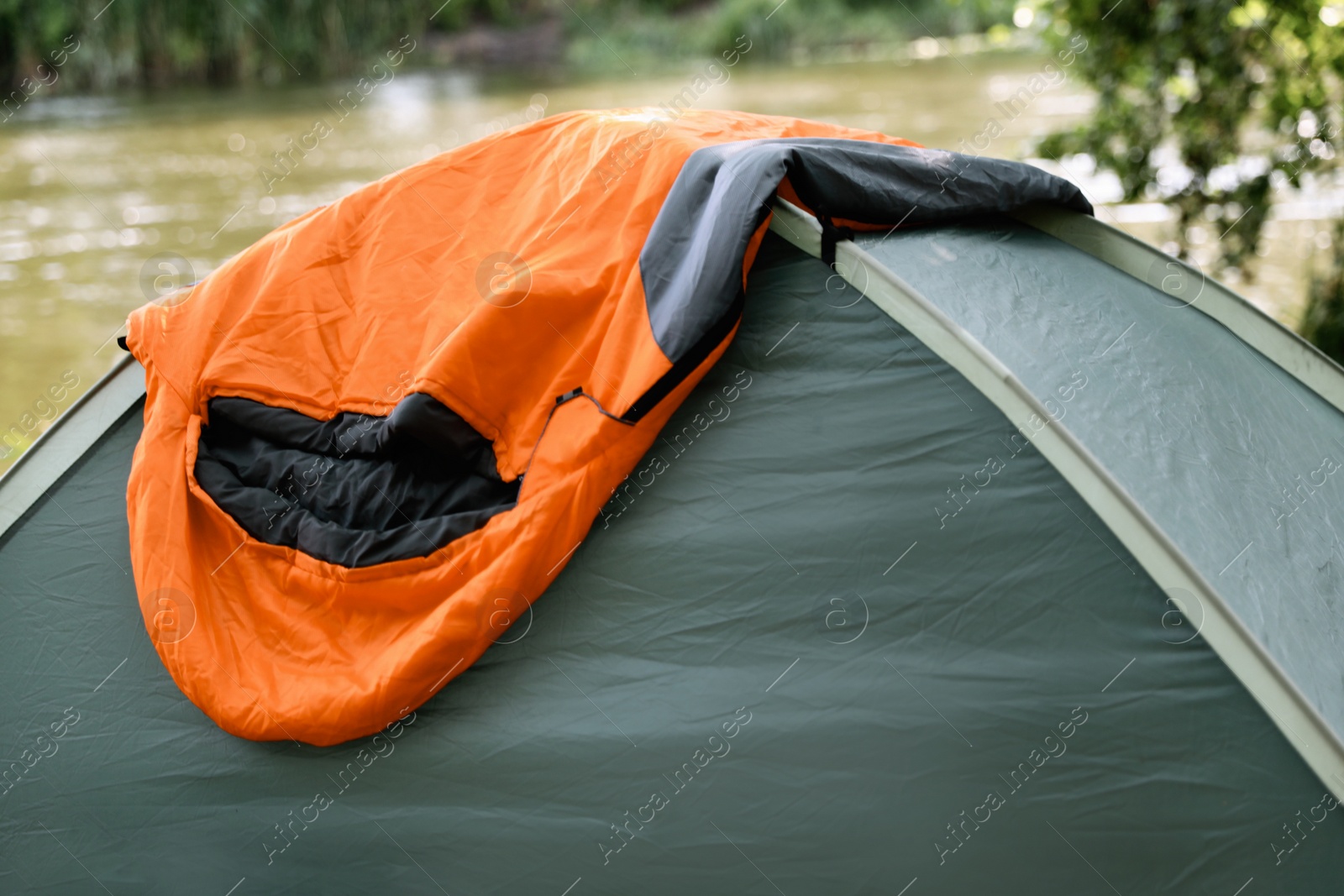 Photo of Tent with sleeping bag outdoors. Camping gear