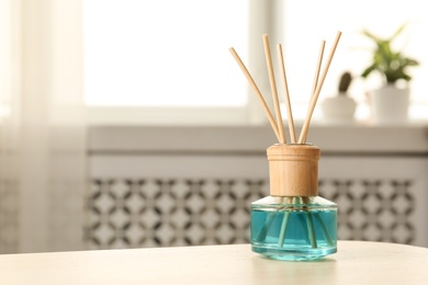 Photo of Reed air freshener on table indoors, space for text