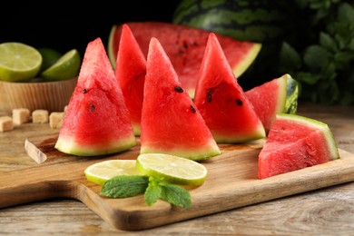 Photo of Tasty juicy watermelon and lime slices on wooden table