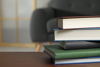 Photo of Stack of hardcover books on wooden table indoors, space for text
