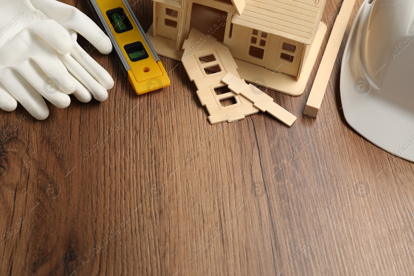 Photo of Building level and other construction tools on wooden table, above view. Space for text