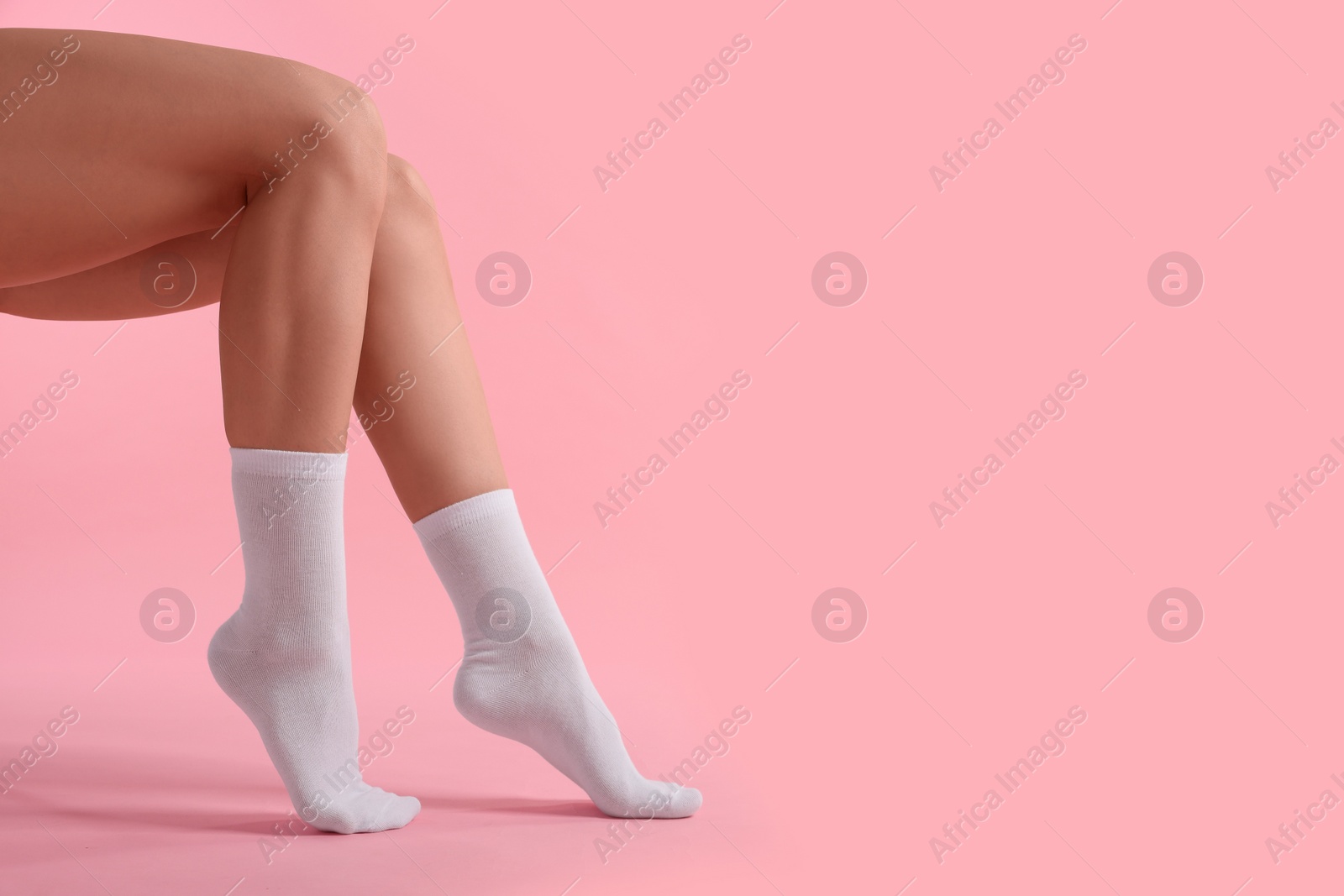 Photo of Woman in stylish white socks on pink background, closeup. Space for text