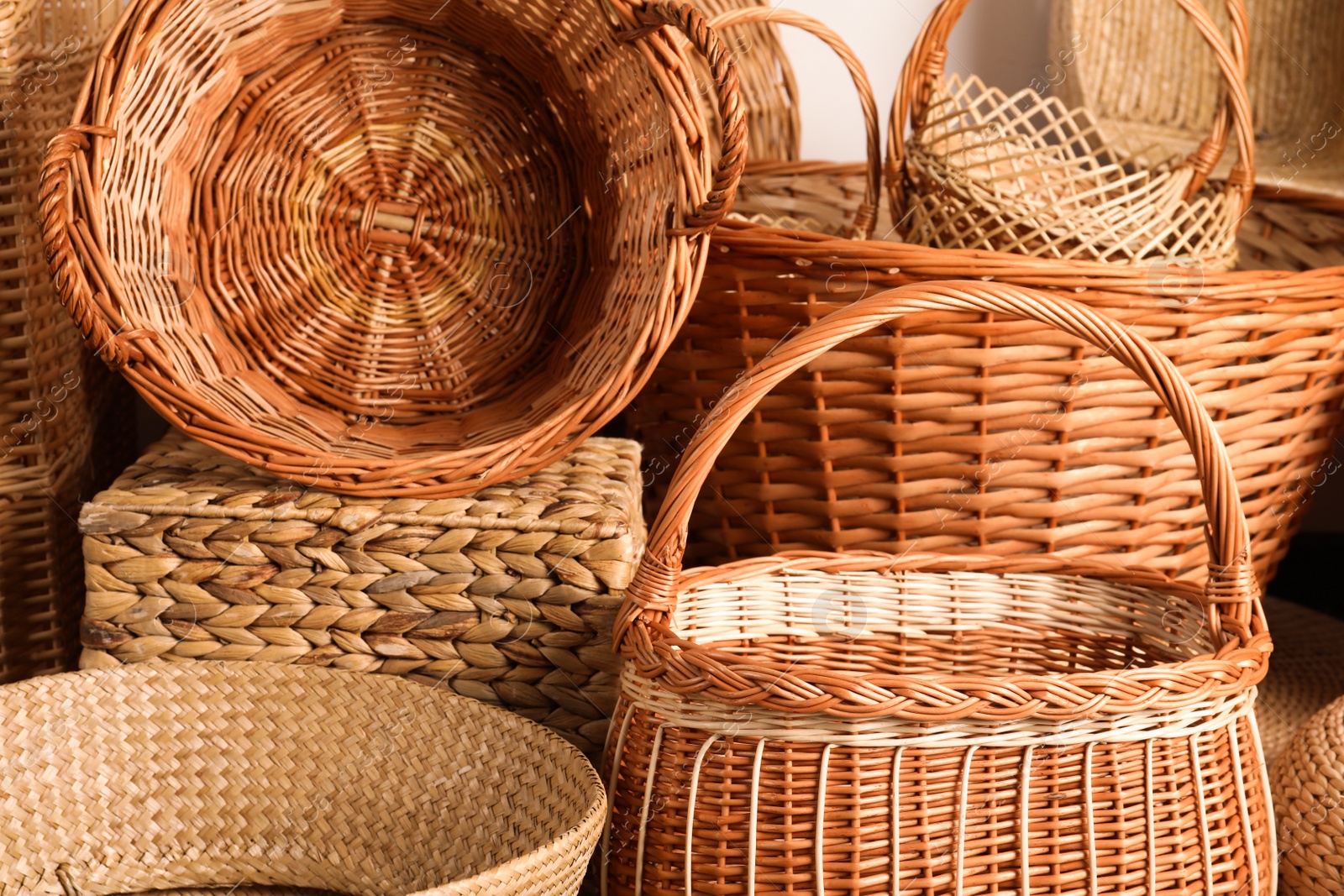 Photo of Many different wicker baskets made of natural material as background, closeup