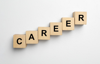 Wooden cubes with word CAREER on white background, flat lay