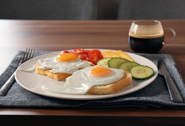 Photo of Tasty toasts with fried eggs, cheese and vegetables on wooden table