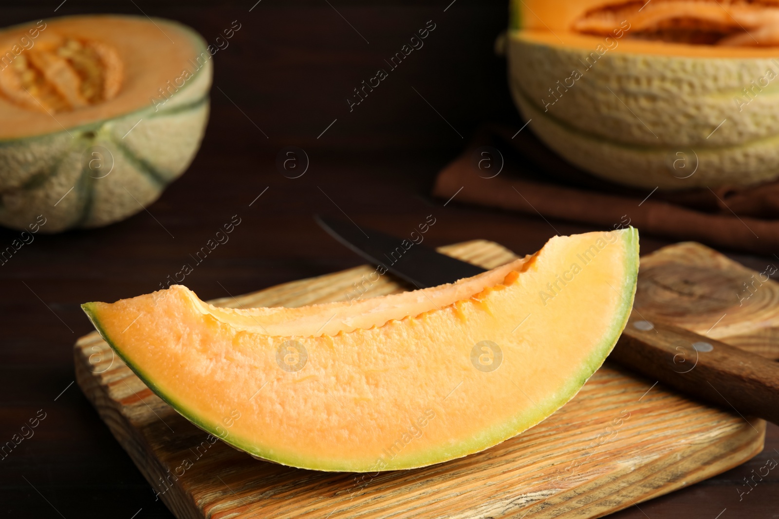 Photo of Slice of tasty fresh melon on wooden board, closeup