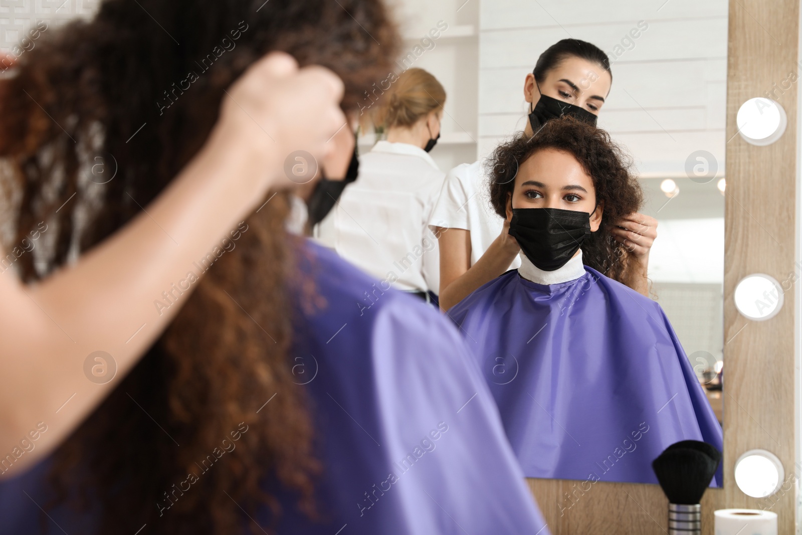 Photo of Professional stylist working with client in salon. Hairdressing services during Coronavirus quarantine