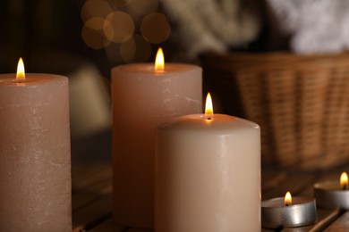 Photo of Spa composition with burning candles on wooden table, closeup. Space for text
