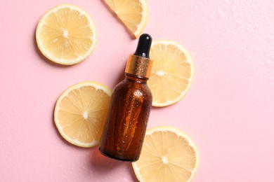 Bottle of cosmetic serum and lemon slices on wet pink background, flat lay