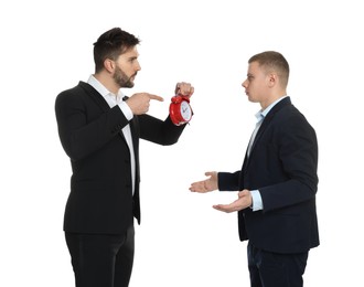 Businessman with alarm clock scolding employee for being late on white background