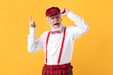 Photo of Portrait of grandpa with stylish hat and bowtie on yellow background