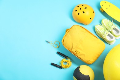 Photo of Different sports equipment on light blue background, flat lay. Space for text