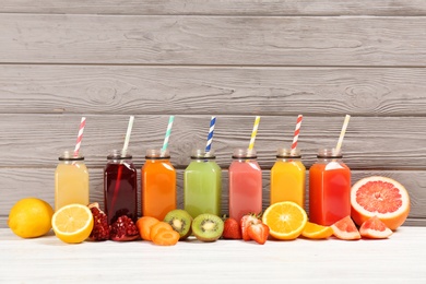 Bottles with tasty juices and ingredients on table