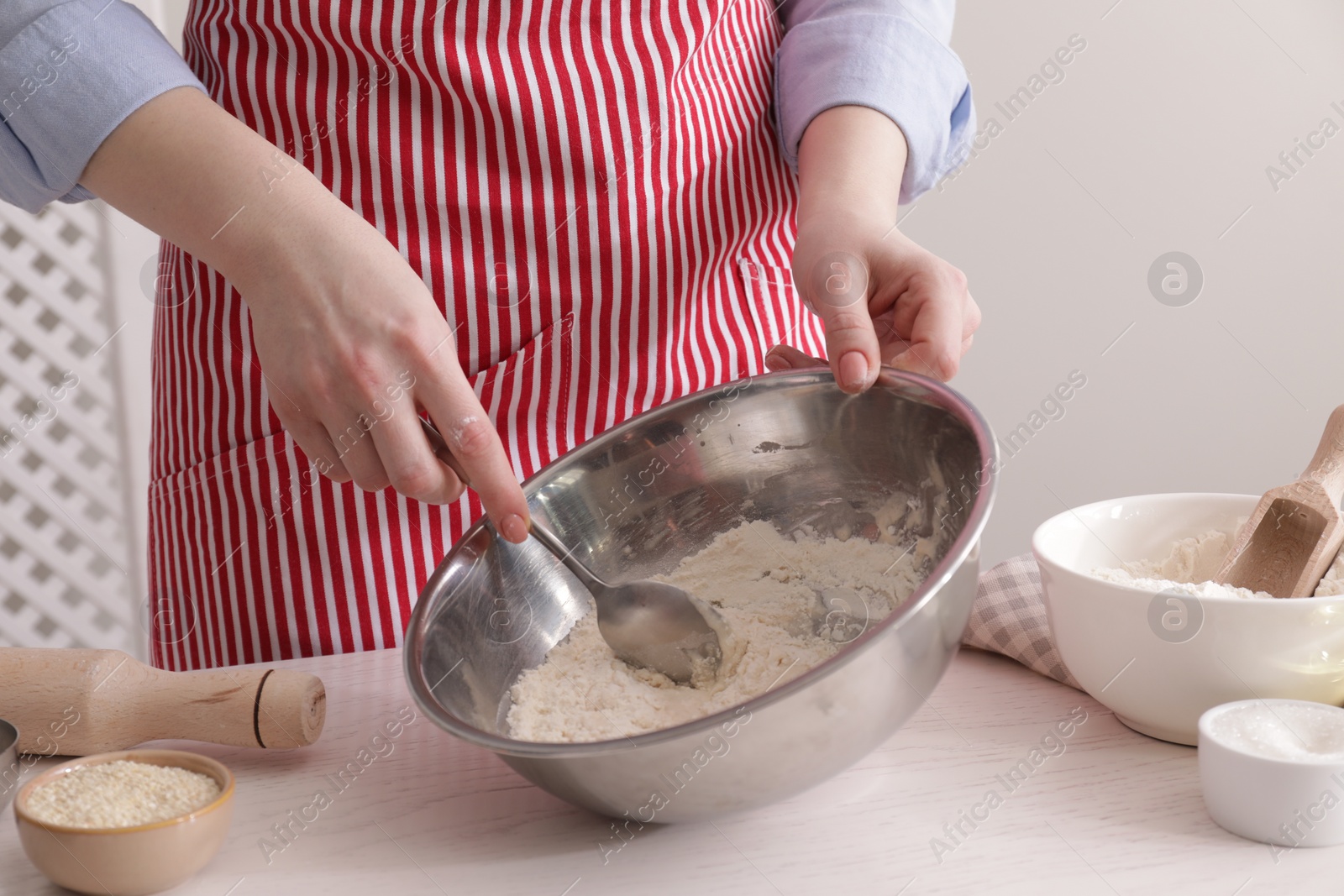 Photo of Woman making traditional grissini at white wooden table indoors, closeup