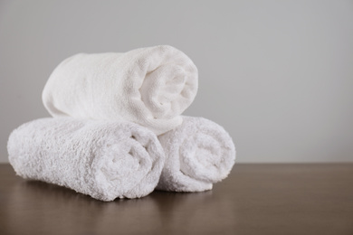 Photo of Clean rolled towels on dark grey table. Space for text