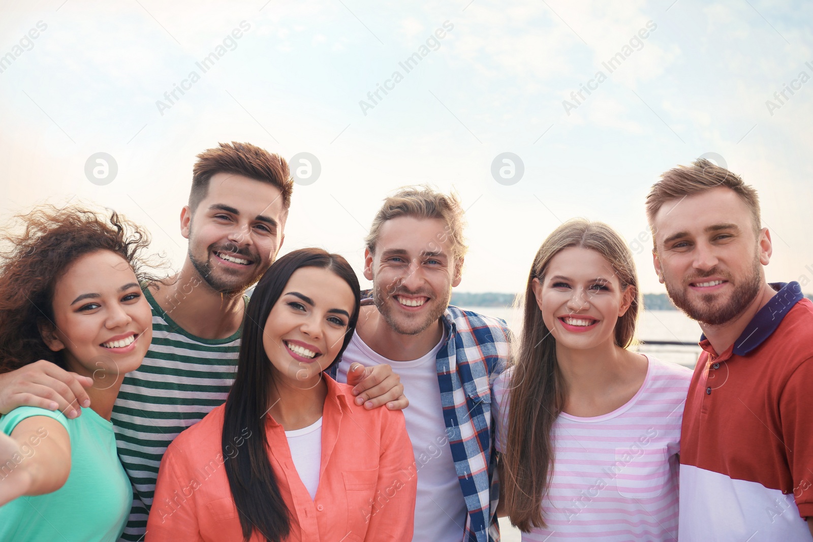 Photo of Happy young people taking selfie outdoors on sunny day