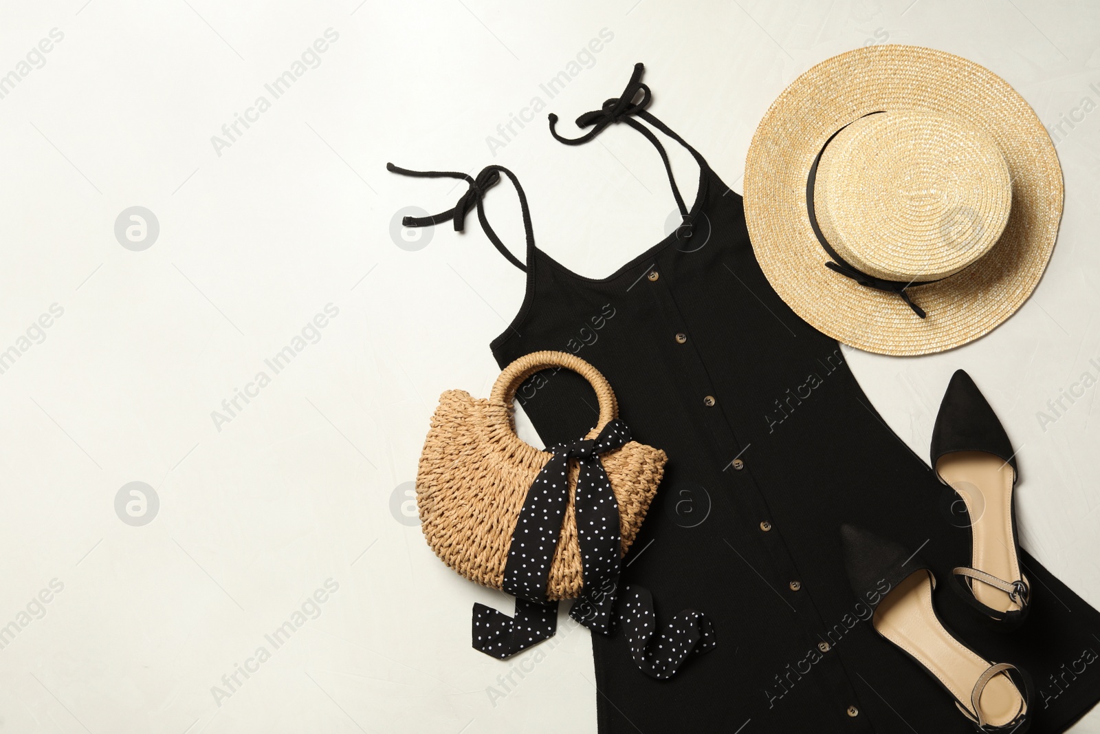 Photo of Flat lay composition with stylish black dress on light background. Space for text