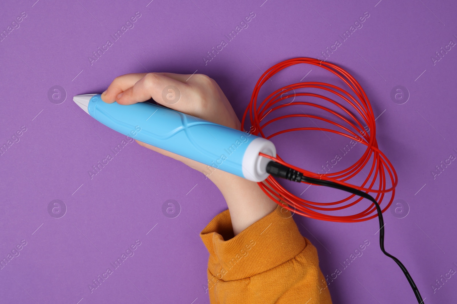 Photo of Boy drawing with stylish 3D pen on purple background, top view