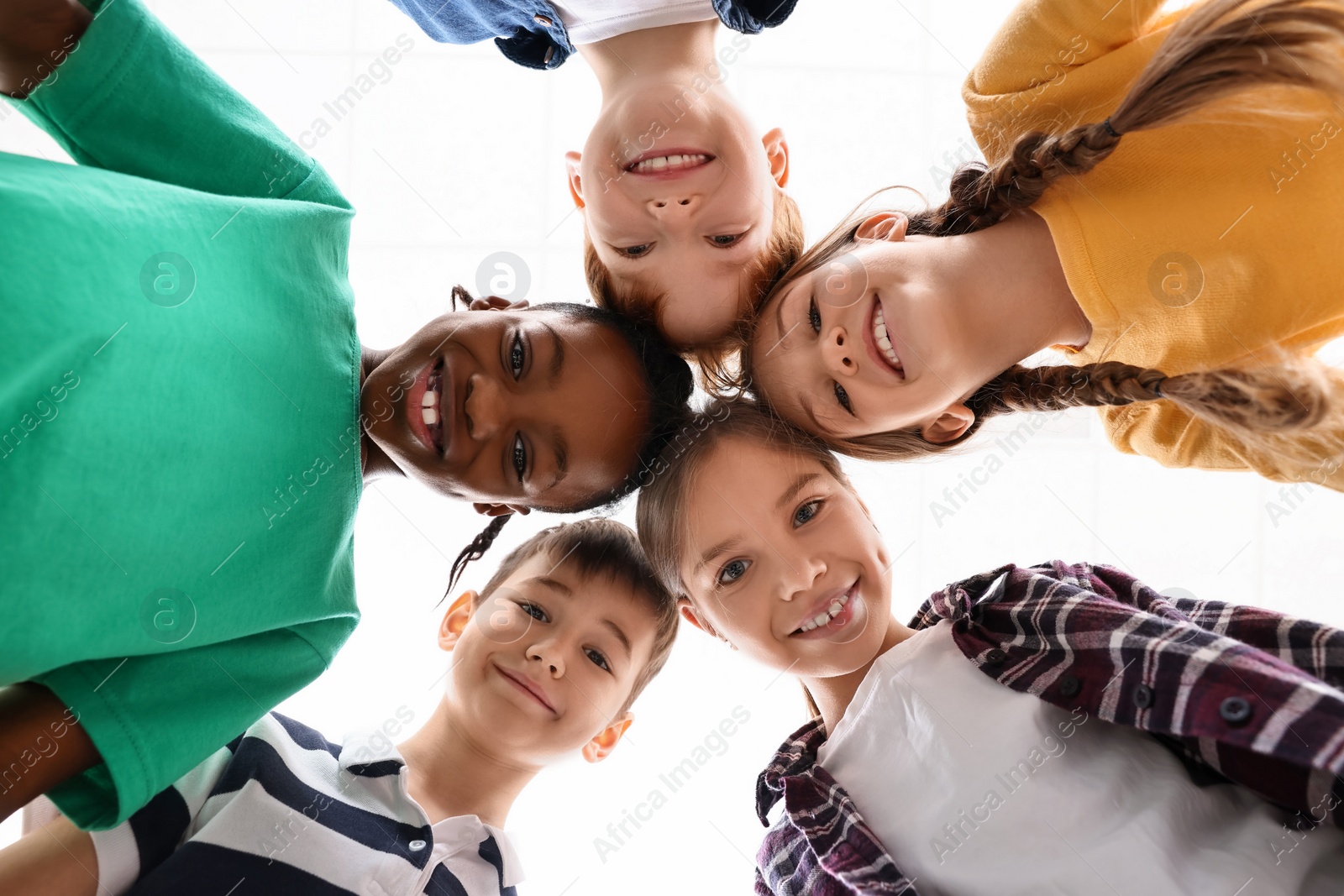 Photo of Happy children huddling at school, bottom view