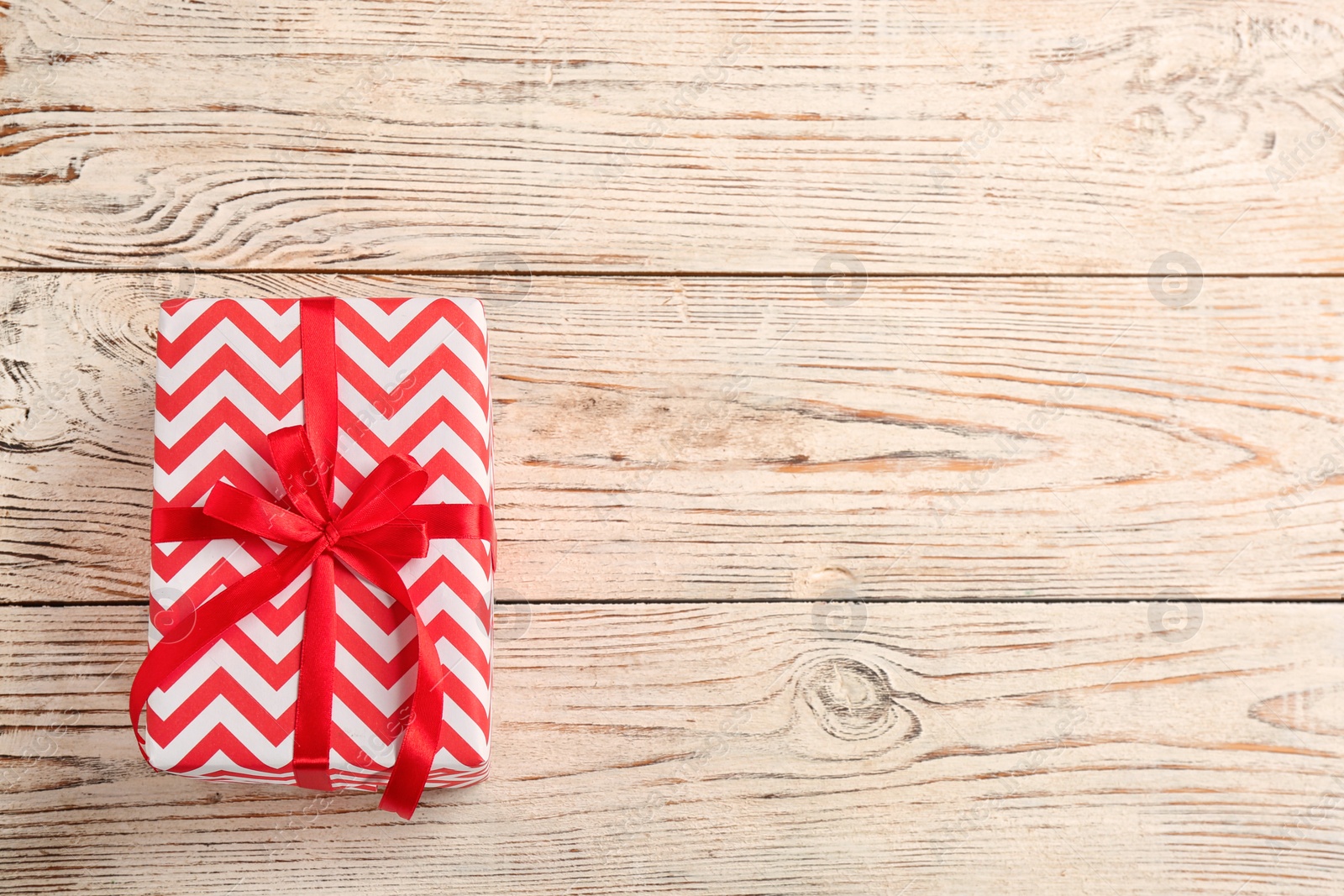 Photo of Elegant gift box with bow on wooden background, top view