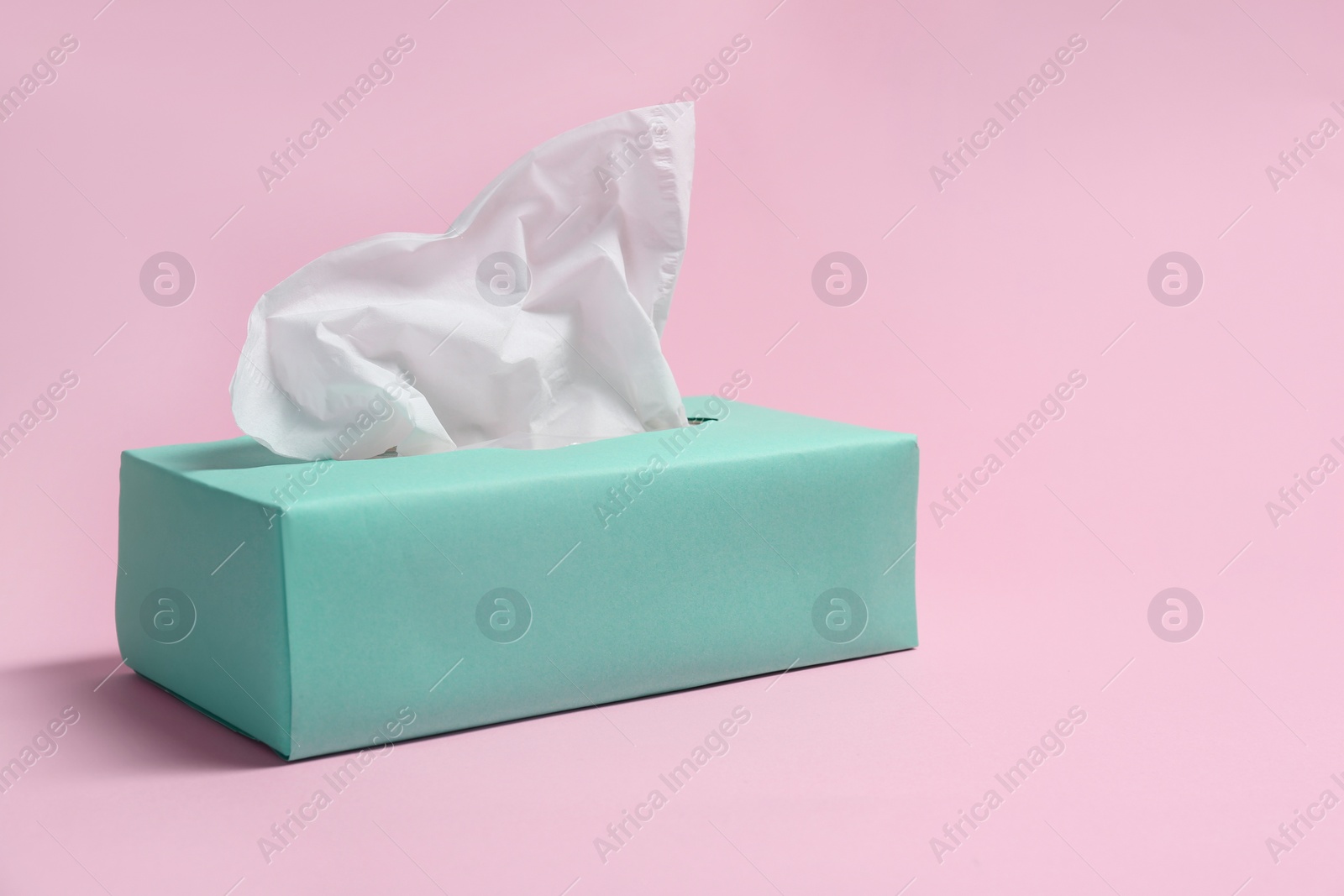 Photo of Box with paper tissues on pink background