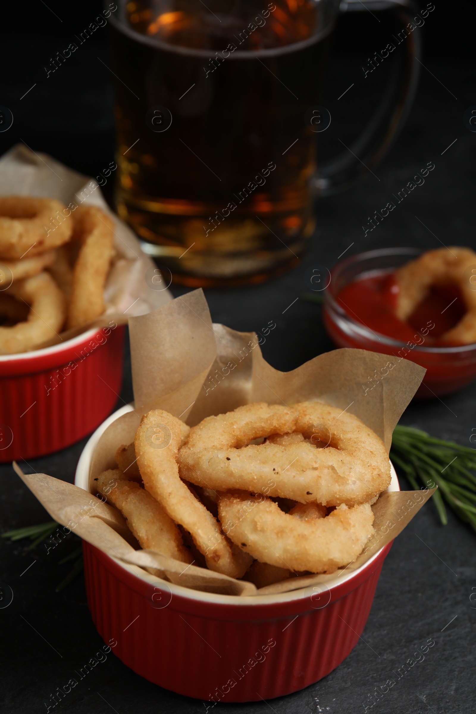 Photo of Fried onion rings served on black table