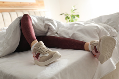 Lazy young woman sleeping on bed instead of morning training, closeup