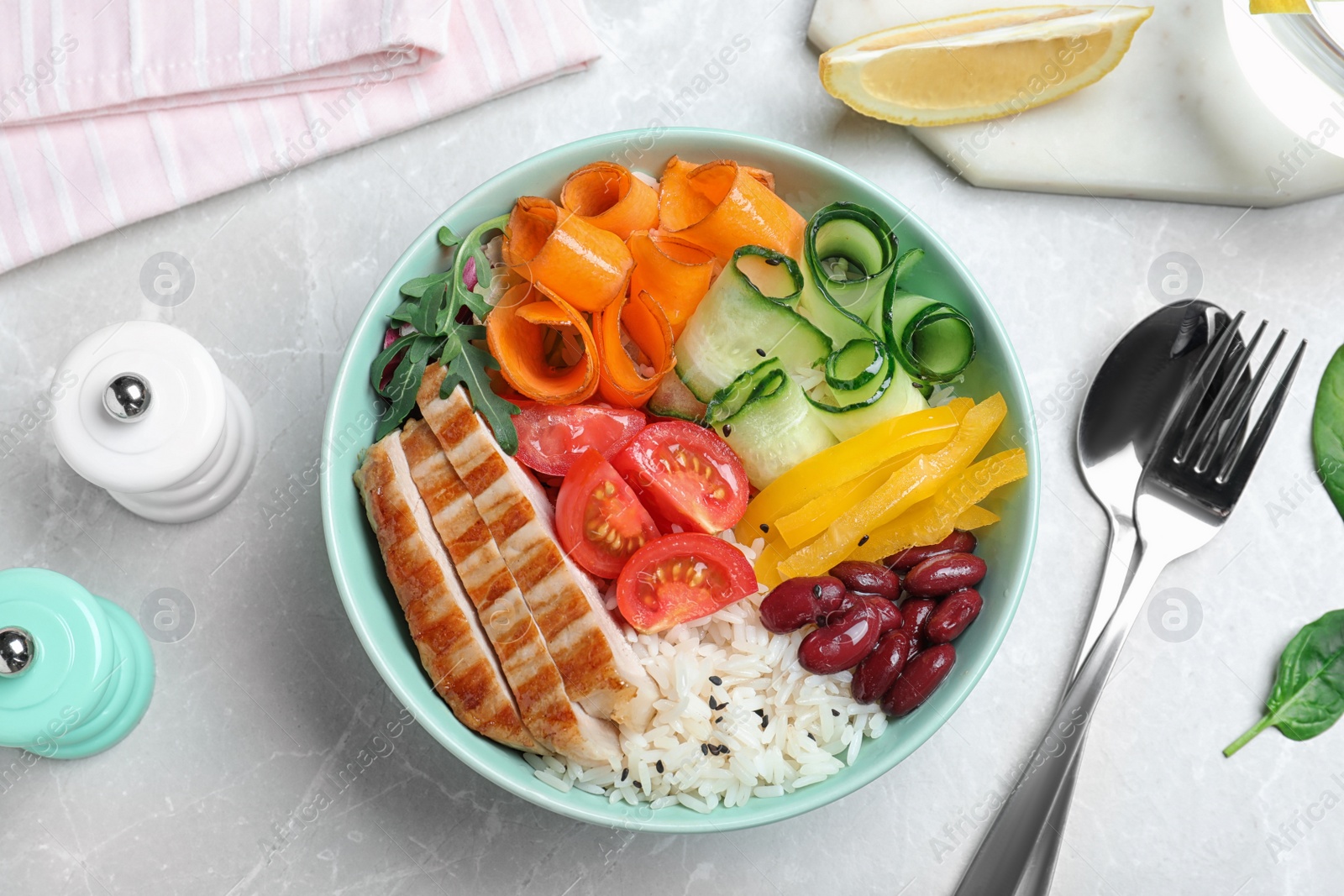 Photo of Tasty rice with beans and chicken meat served on light grey marble table, flat lay