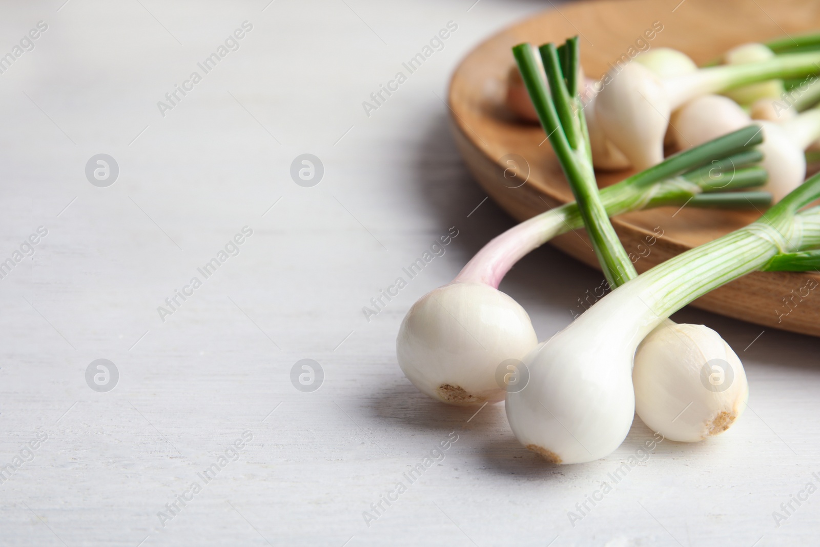 Photo of Fresh green onion on wooden table, closeup